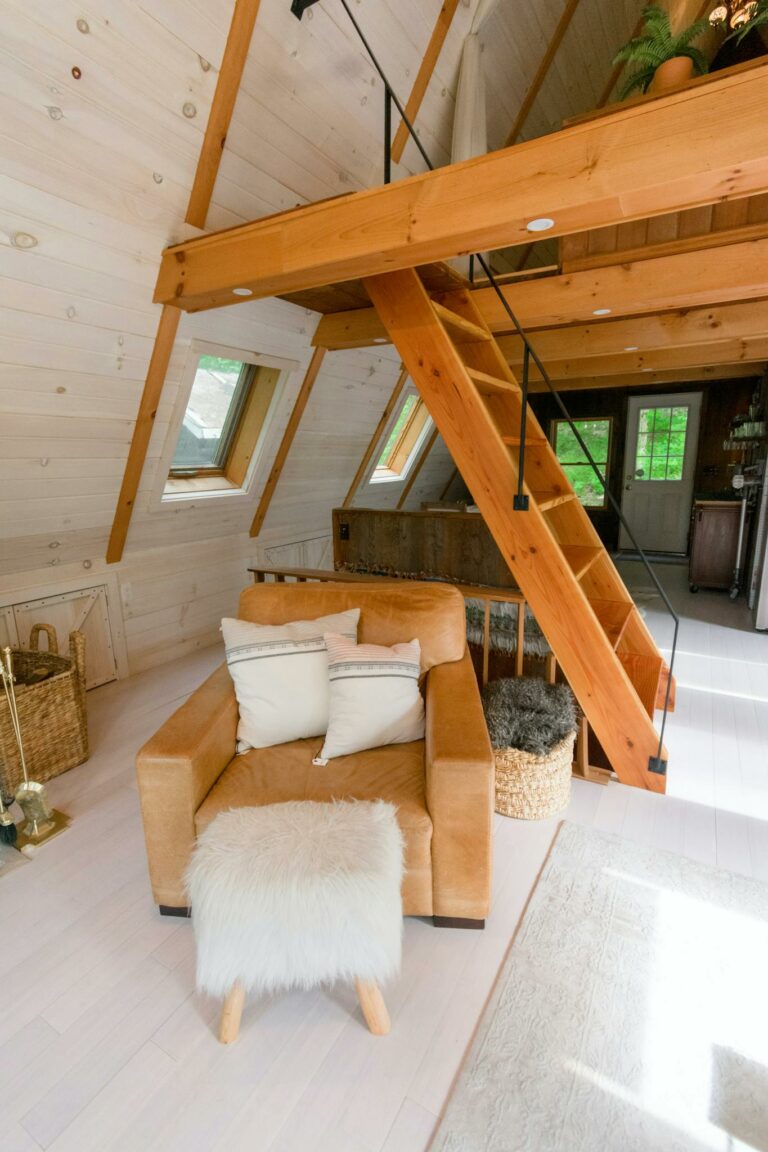 A comfortable chair and wooden loft in a modern A-frame interior in Stowe, VT.